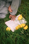 A person sitting in the grass reading a book