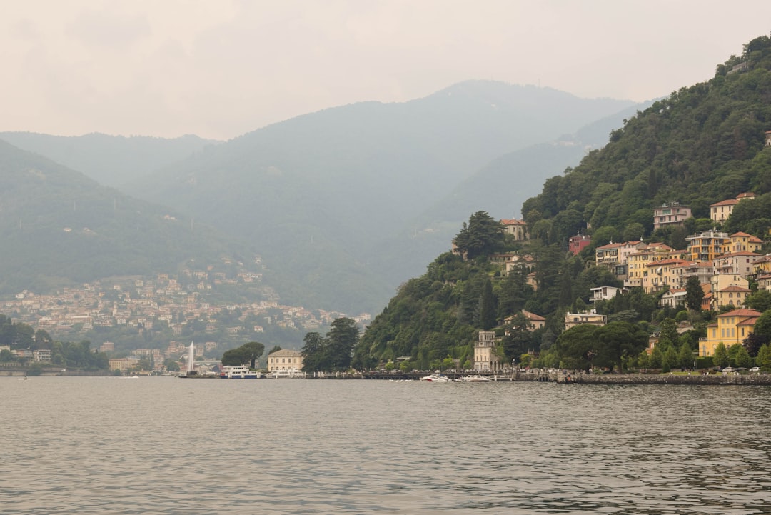 A body of water surrounded by mountains and houses,
