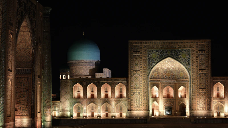 The illuminated turquoise domes and towering minarets of Registan Square in Samarkand, Uzbekistan at night