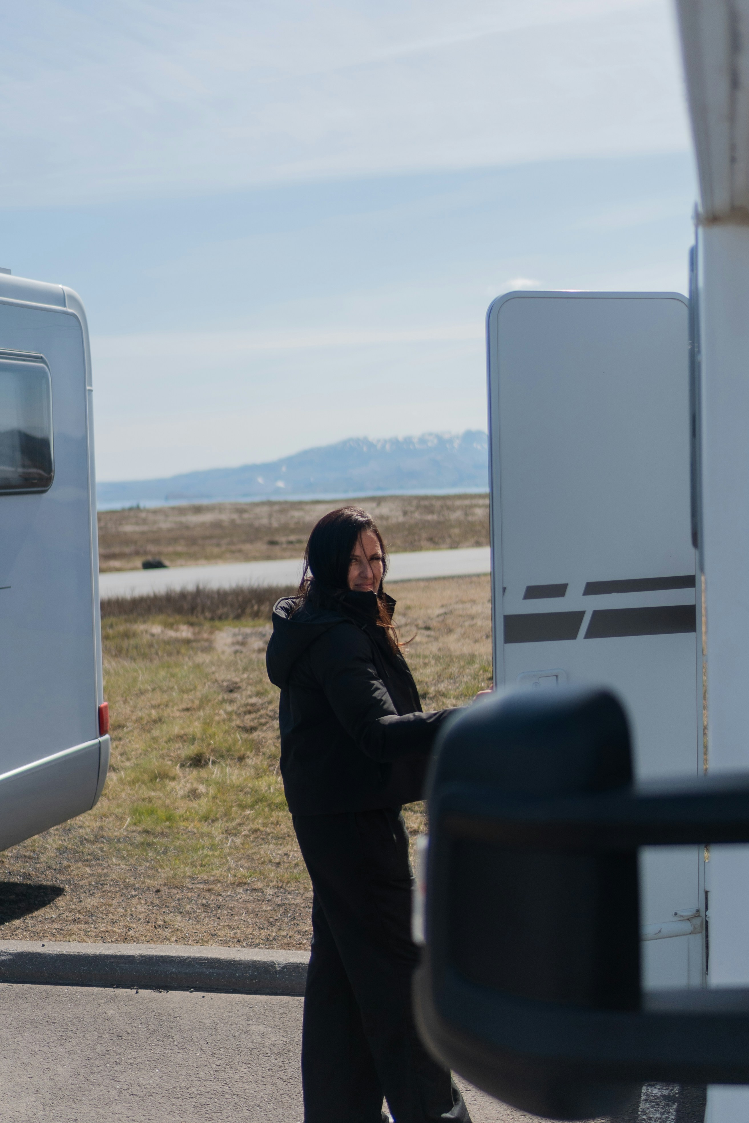 A woman standing in front of a trailer talking on a cell phone