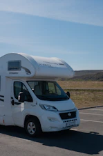 A white motor home parked in a parking lot