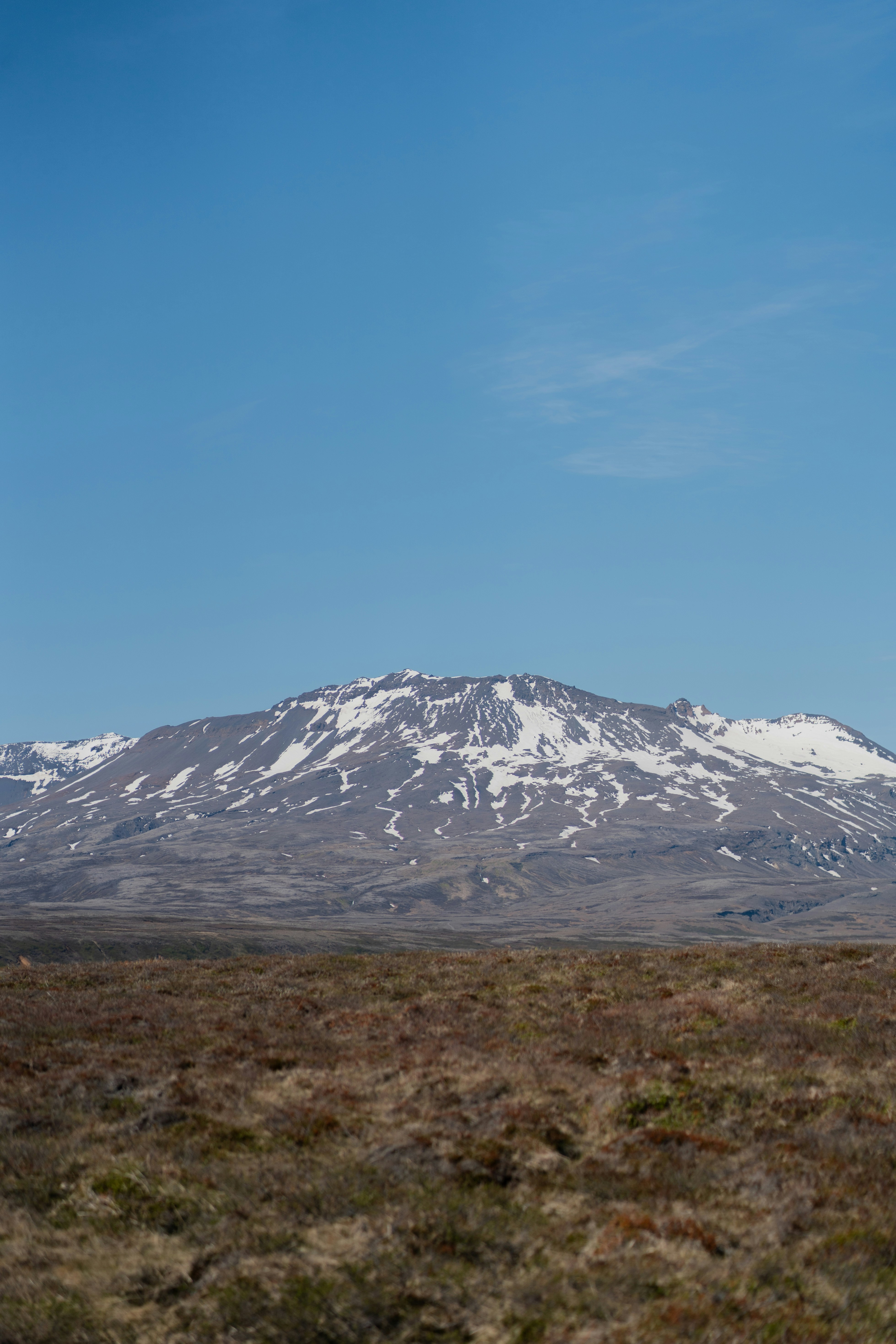 A snow covered mountain in the middle of a field