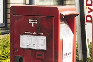 A red mailbox sitting in front of a building