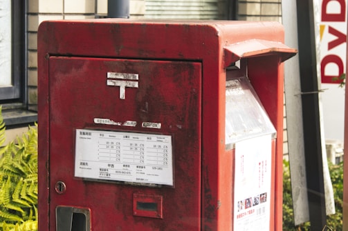 A red mailbox sitting in front of a building