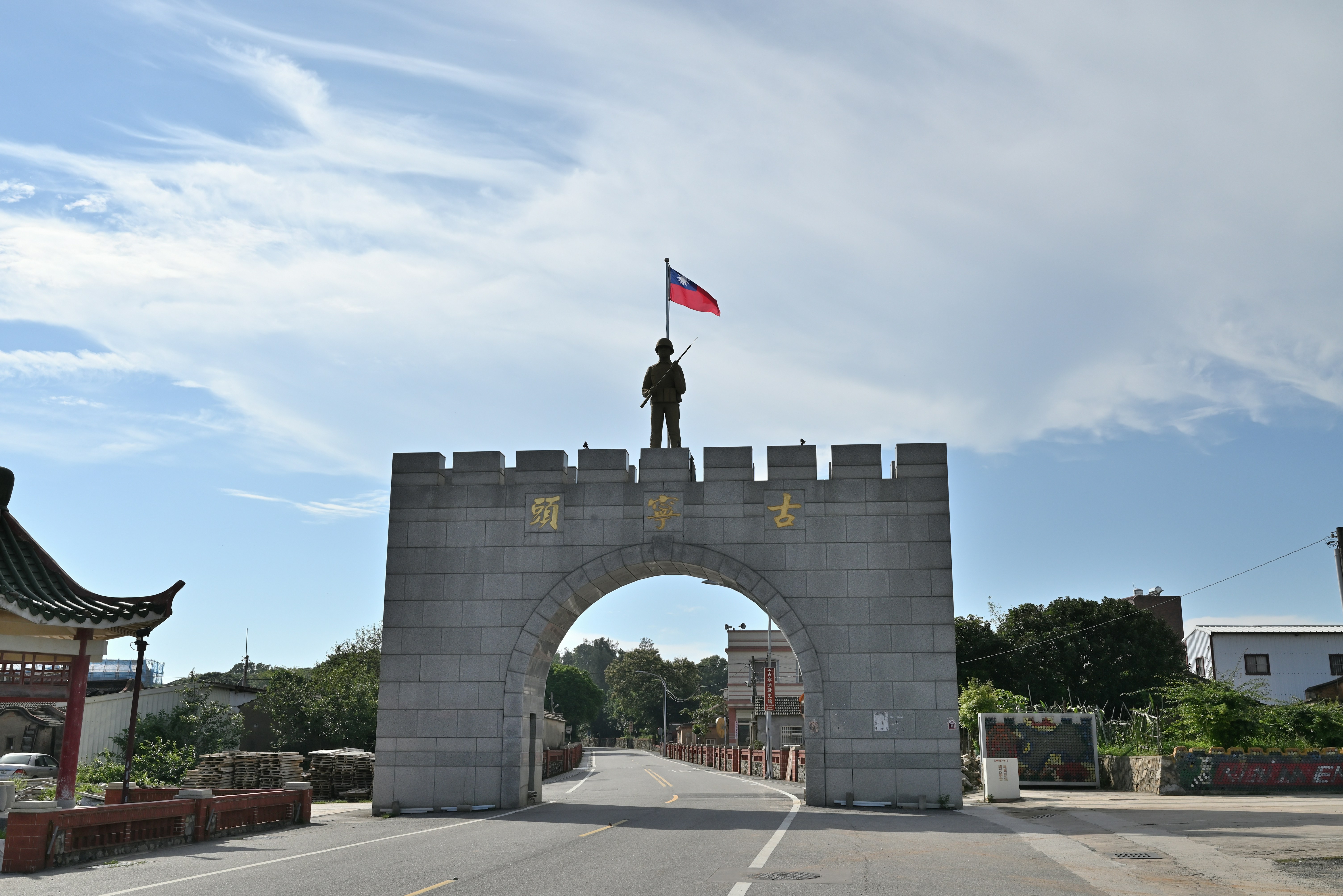 A man standing on top of a stone gate