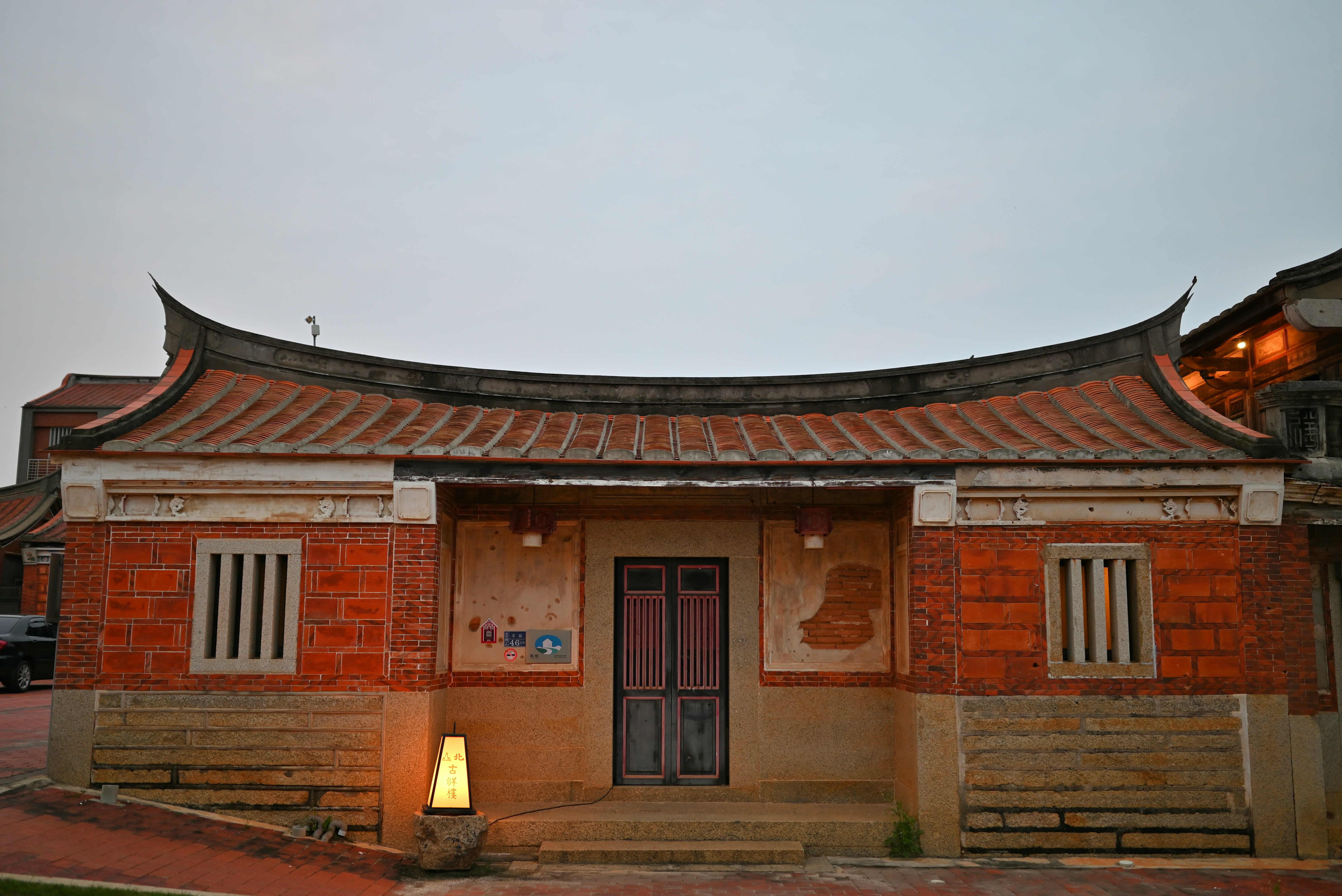 A small building with a lamp in front of it