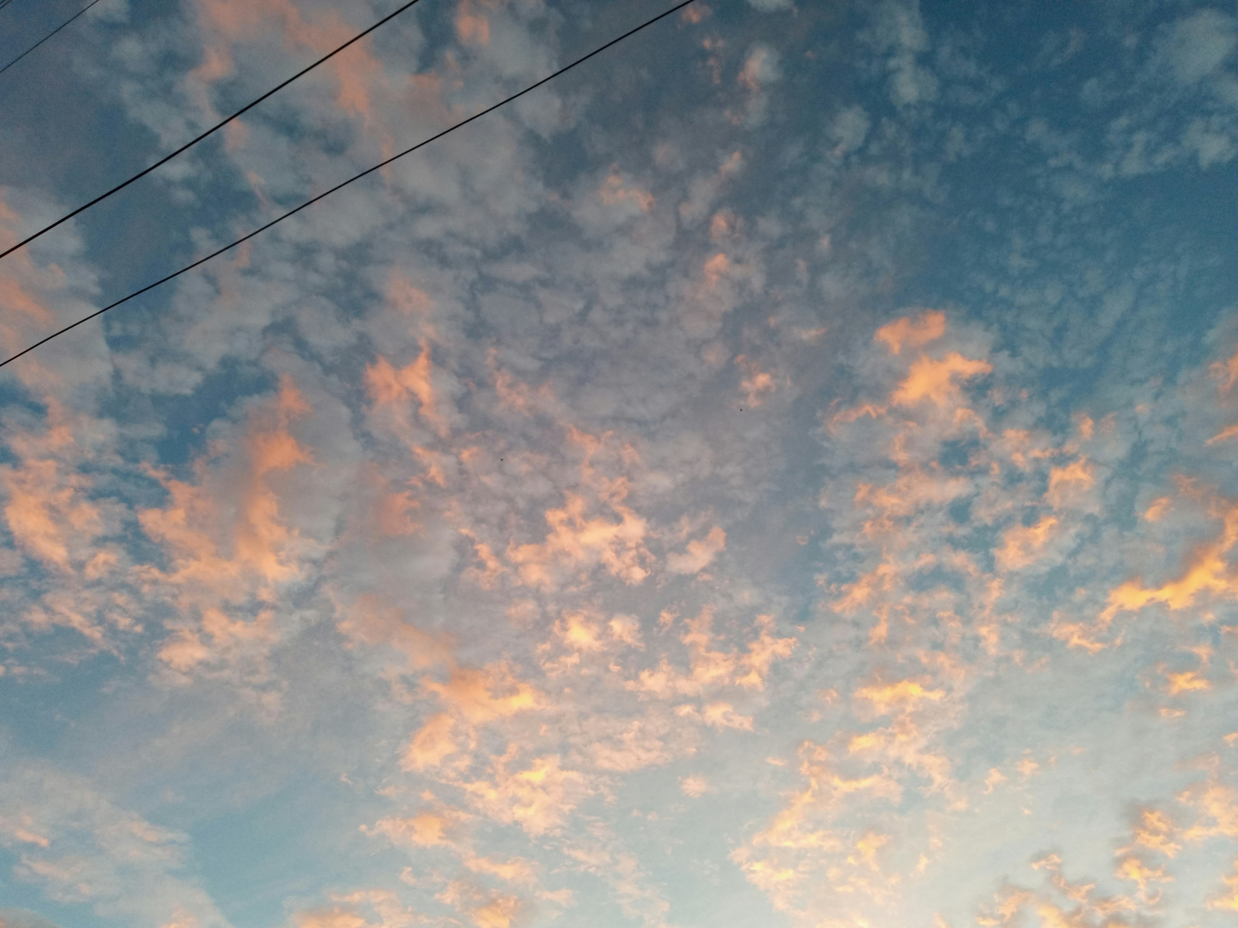 The sky is filled with clouds as the sun sets