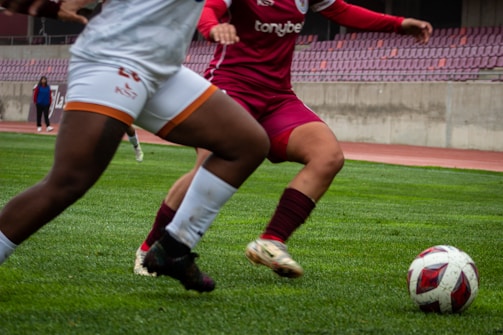 A couple of women playing a game of soccer