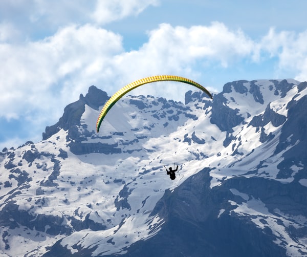 Paraglider soaring over mountain valley