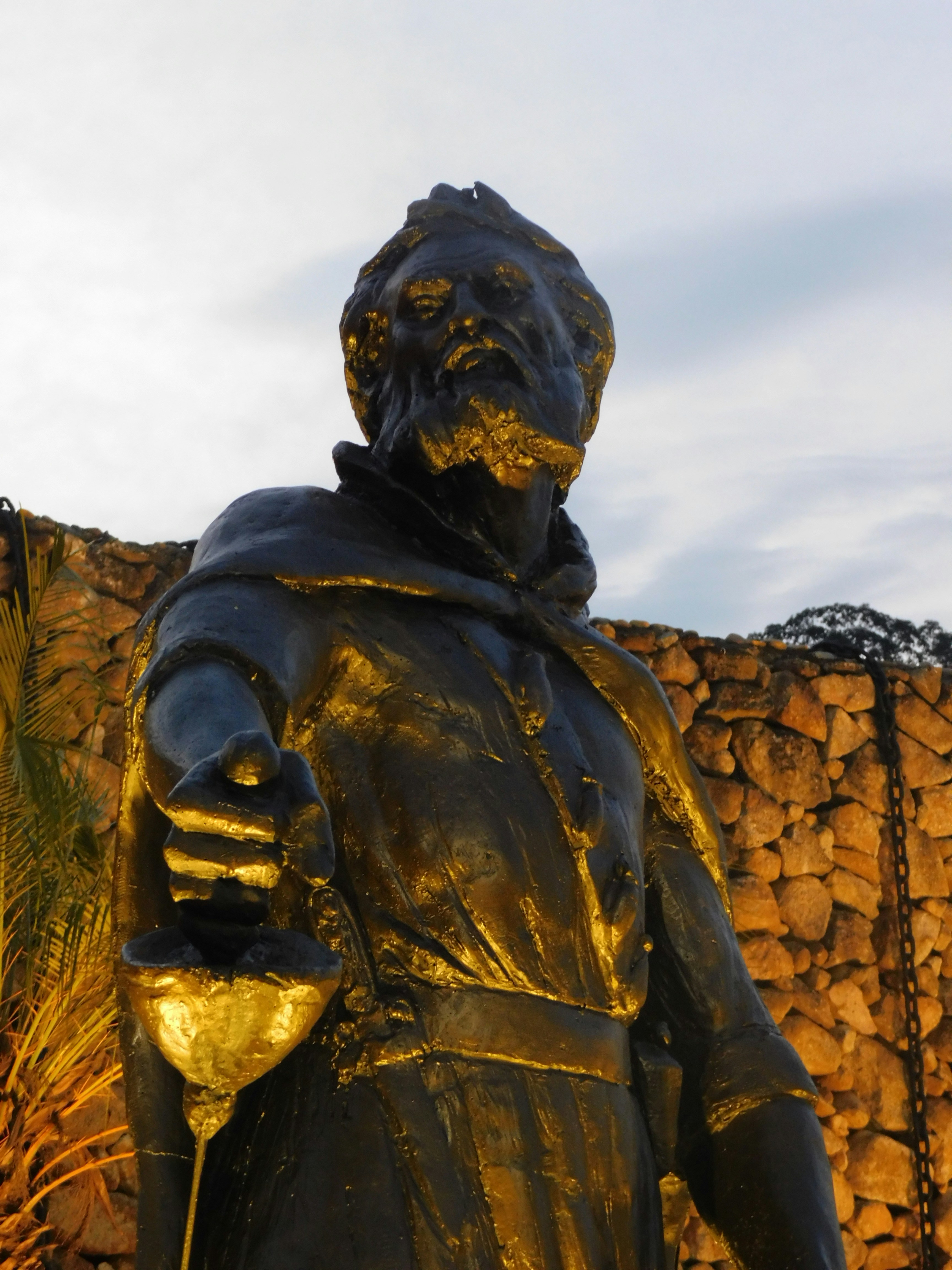 Uma estátua dourada de um homem em um manto
