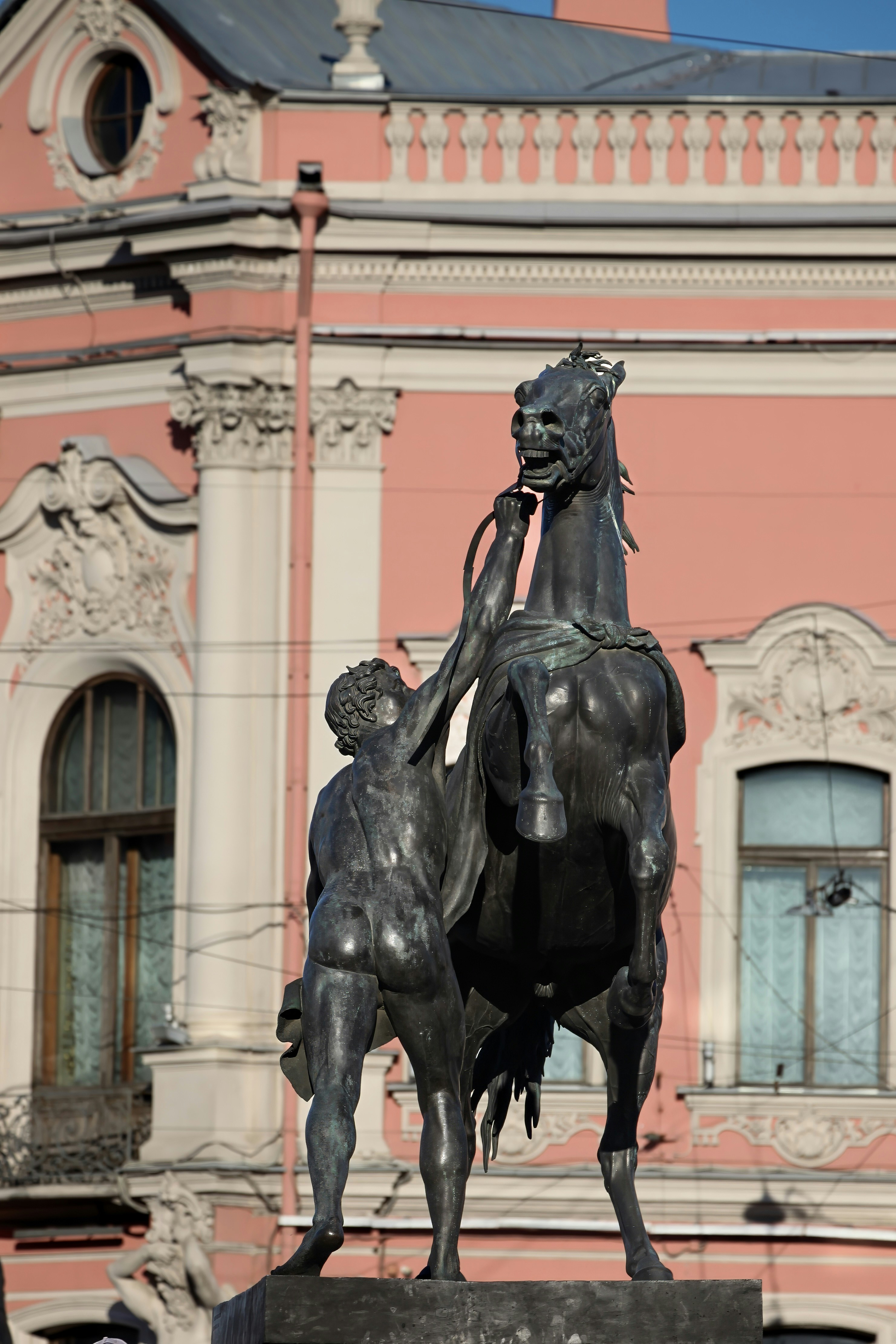 A statue of a man on a horse in front of a building