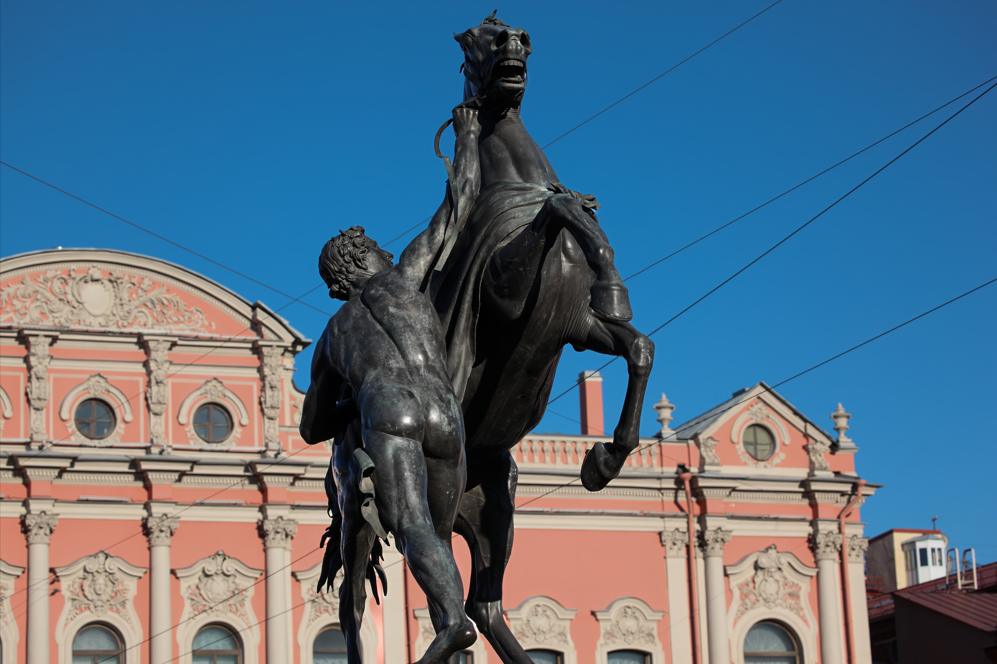 A statue of a man on a horse in front of a building