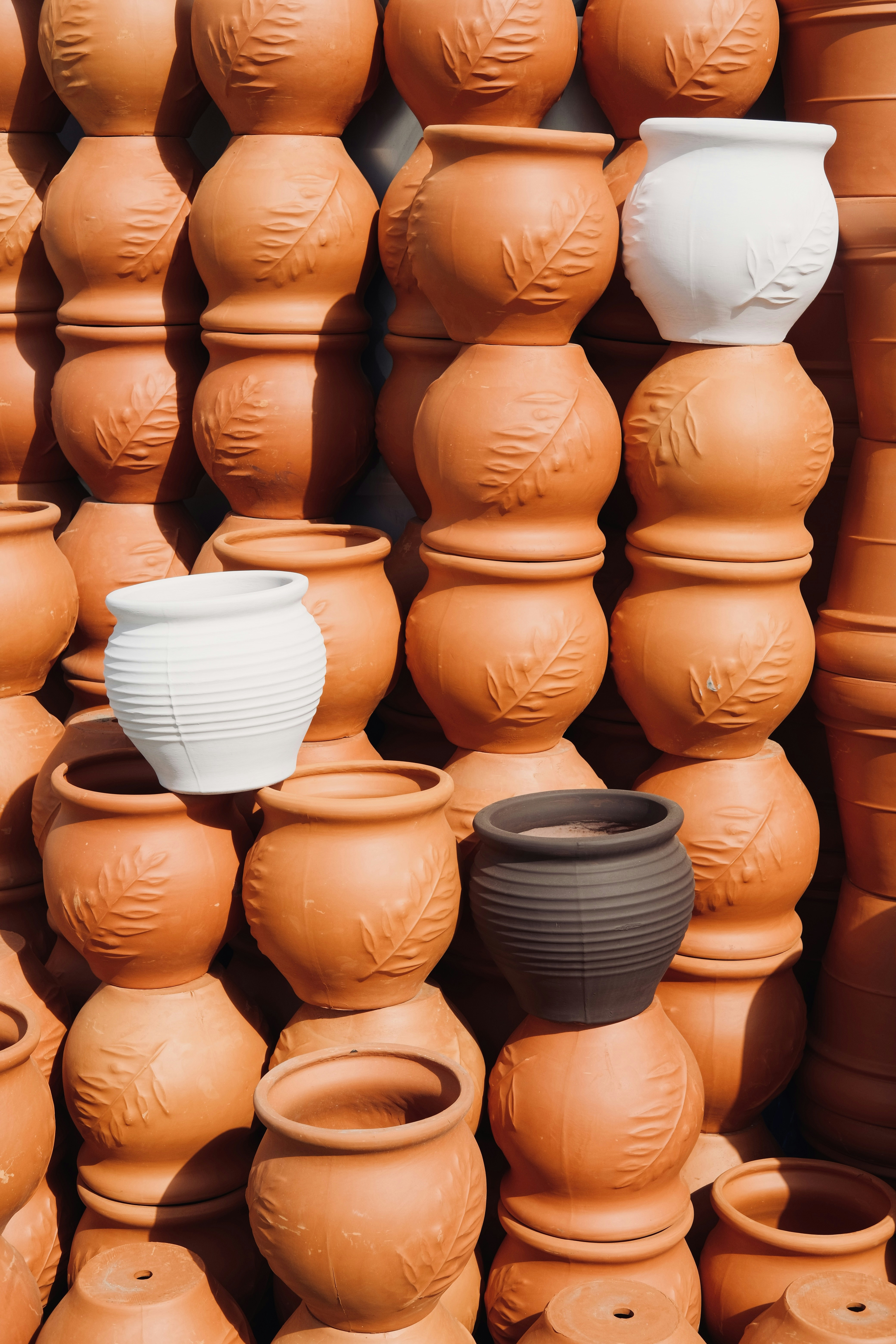 A large number of clay pots are stacked together