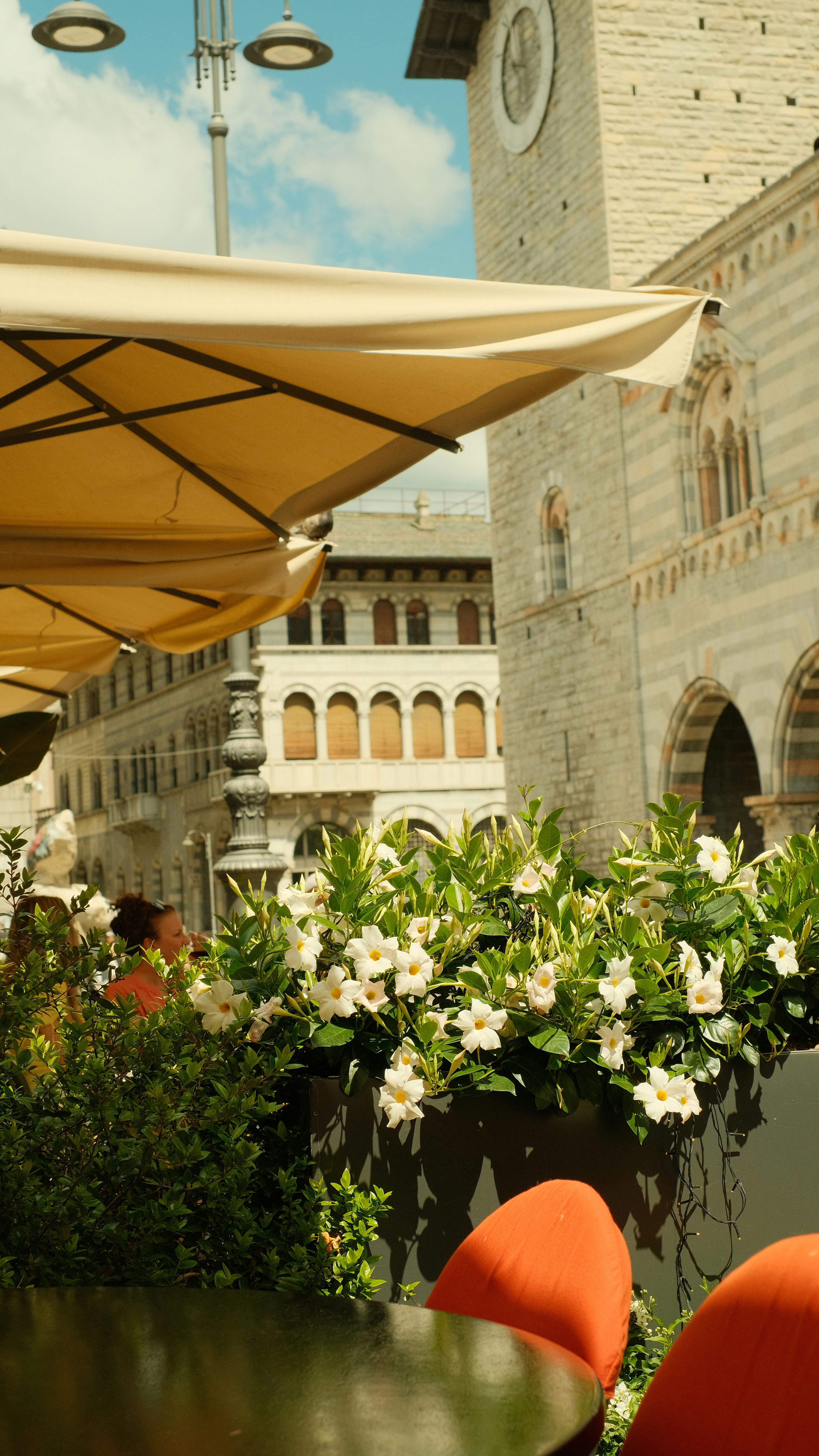 A table with chairs and umbrellas in front of a building