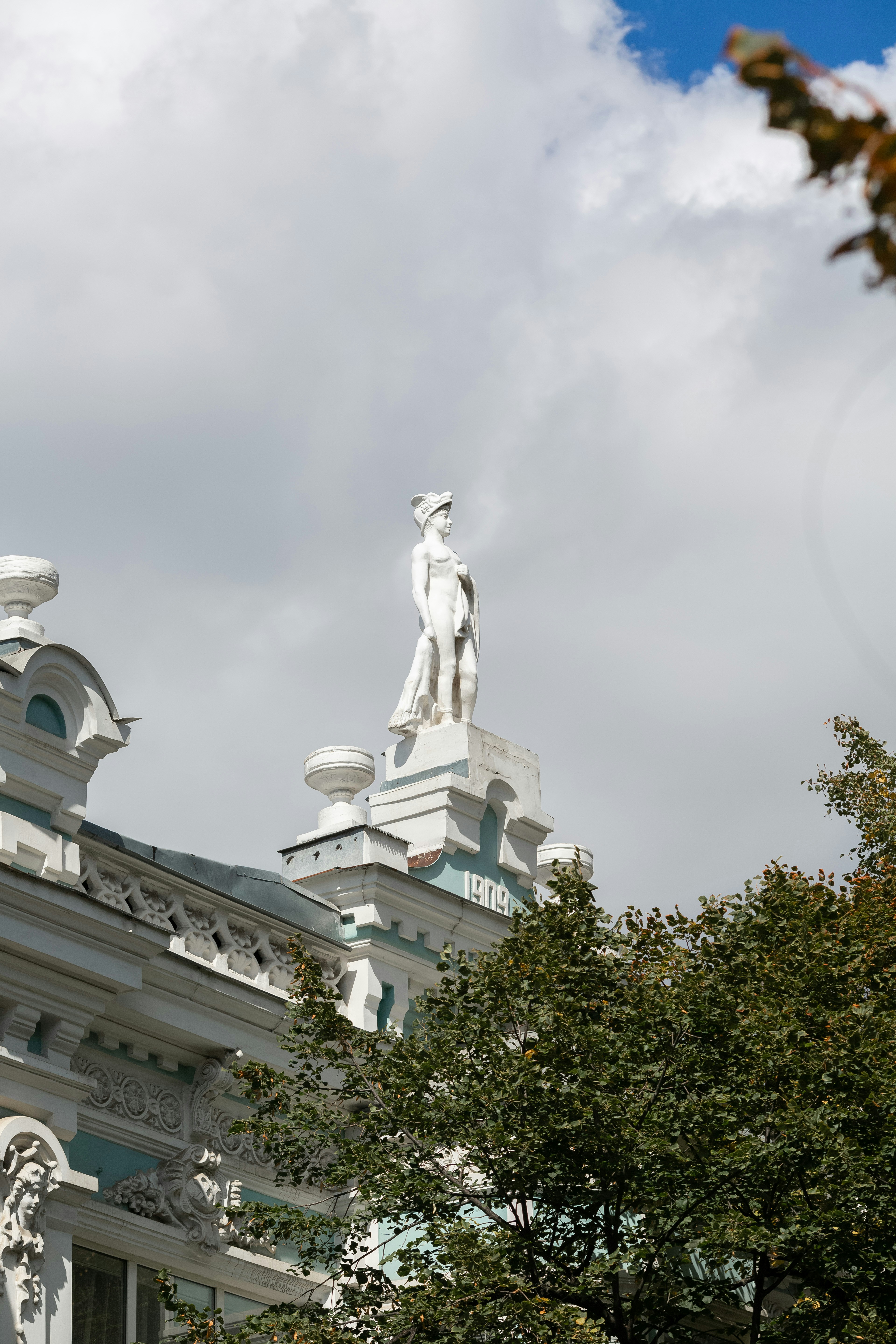 A white building with a statue on top of it