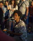 A man playing a guitar in front of a group of people