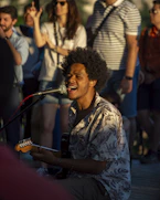 A man playing a guitar in front of a group of people
