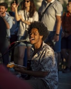 A man playing a guitar in front of a group of people