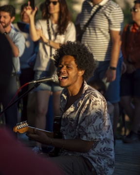 A man playing a guitar in front of a group of people
