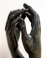 A sculpture of two hands touching each other
