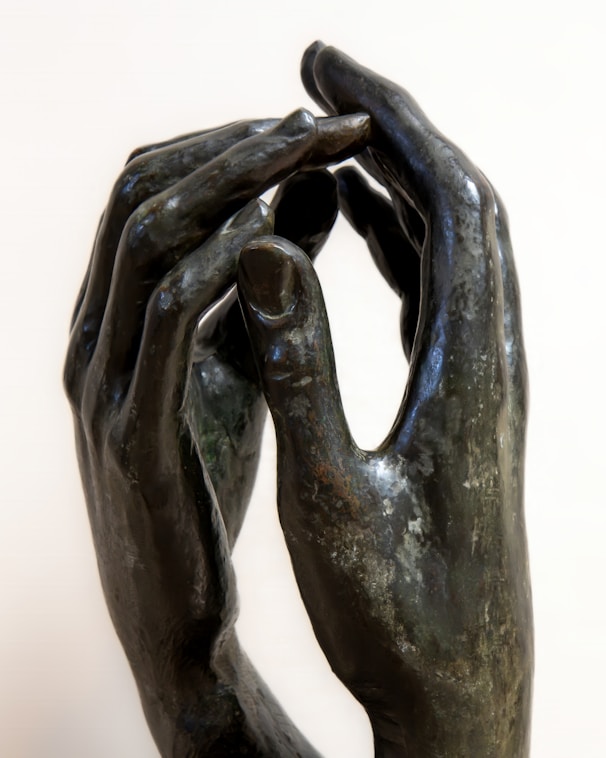 A sculpture of two hands touching each other