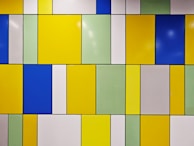 A tiled wall with different colored tiles on it