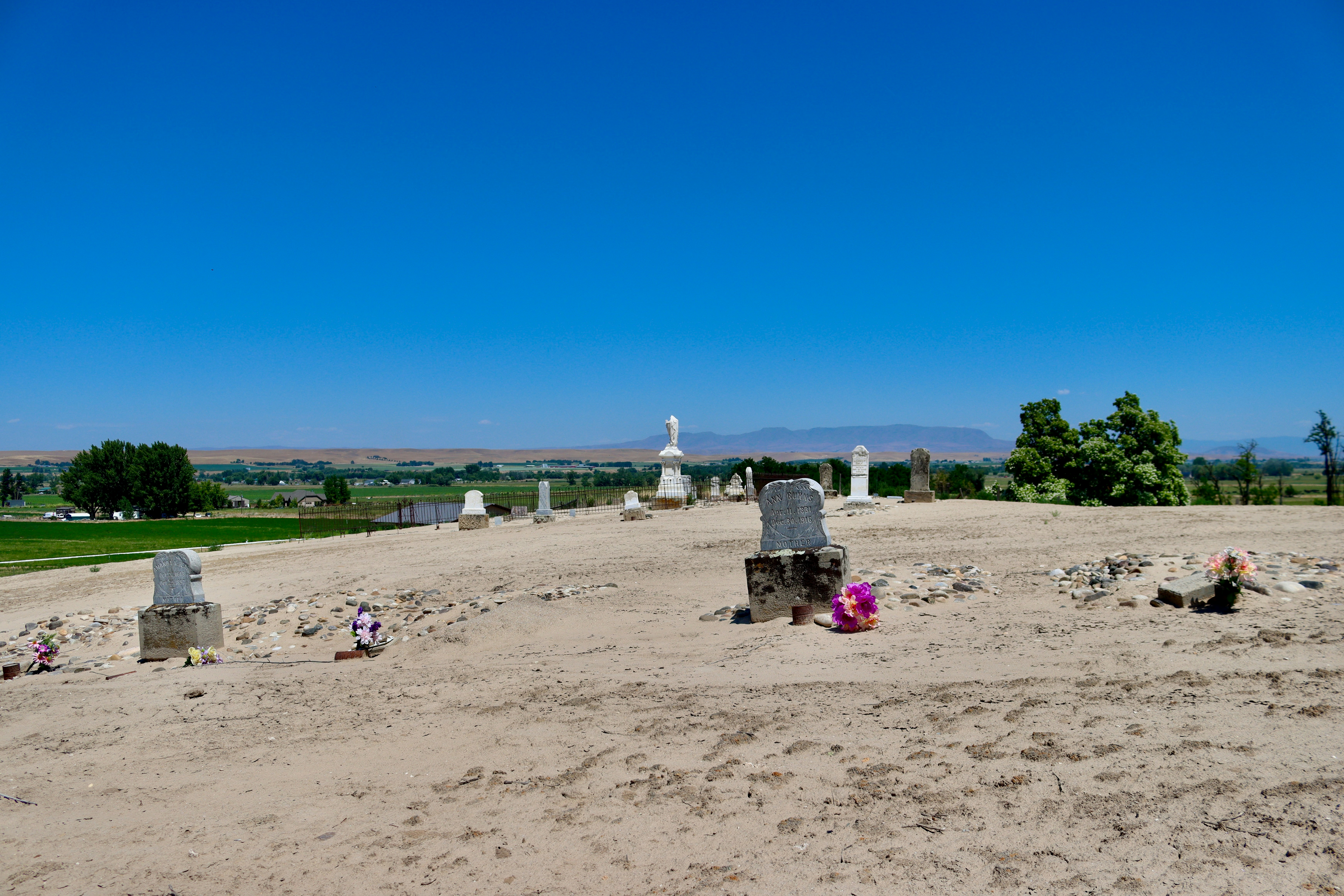 A group of tombstones sitting on top of a dirt field