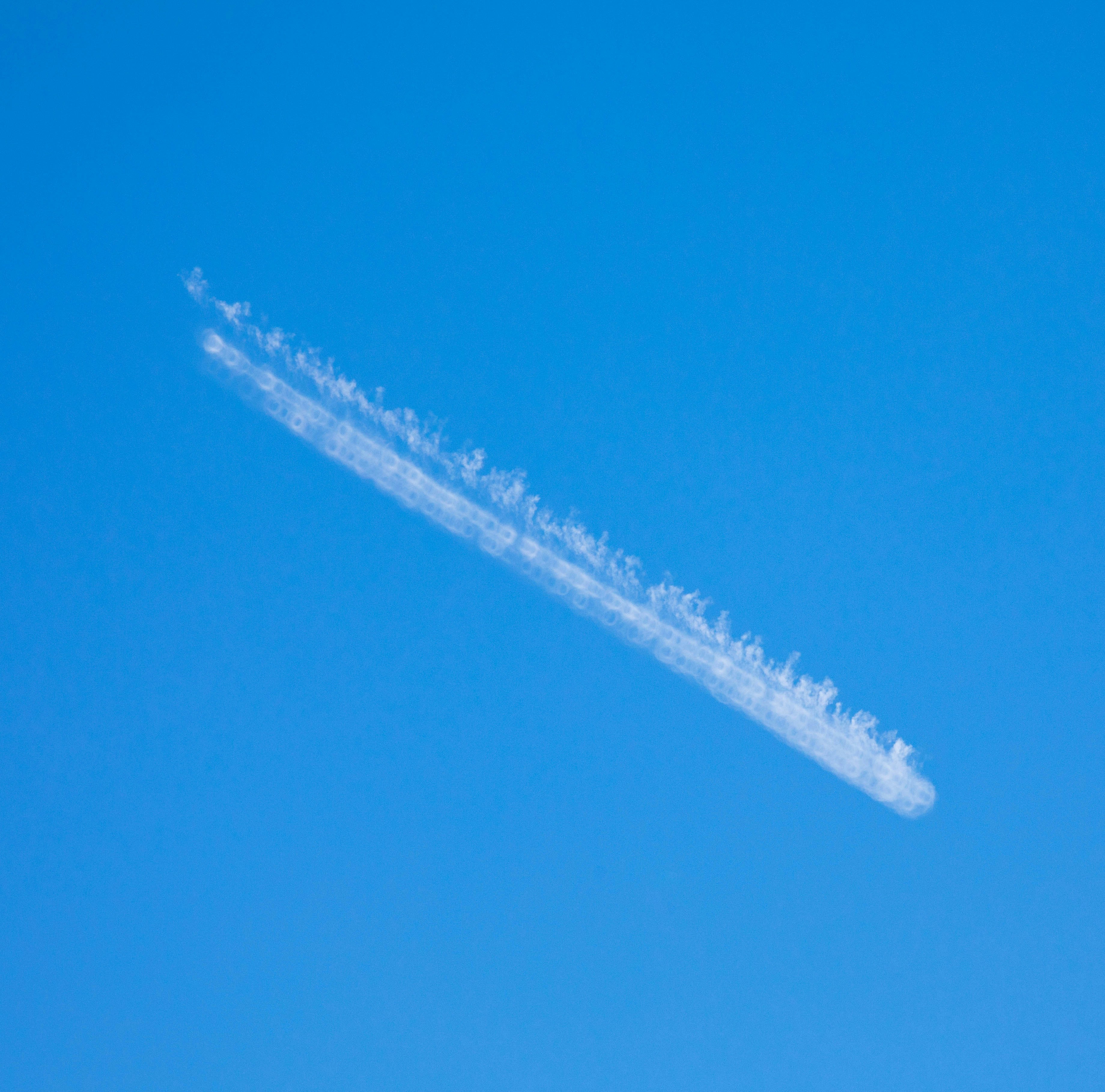 An airplane is flying in the blue sky