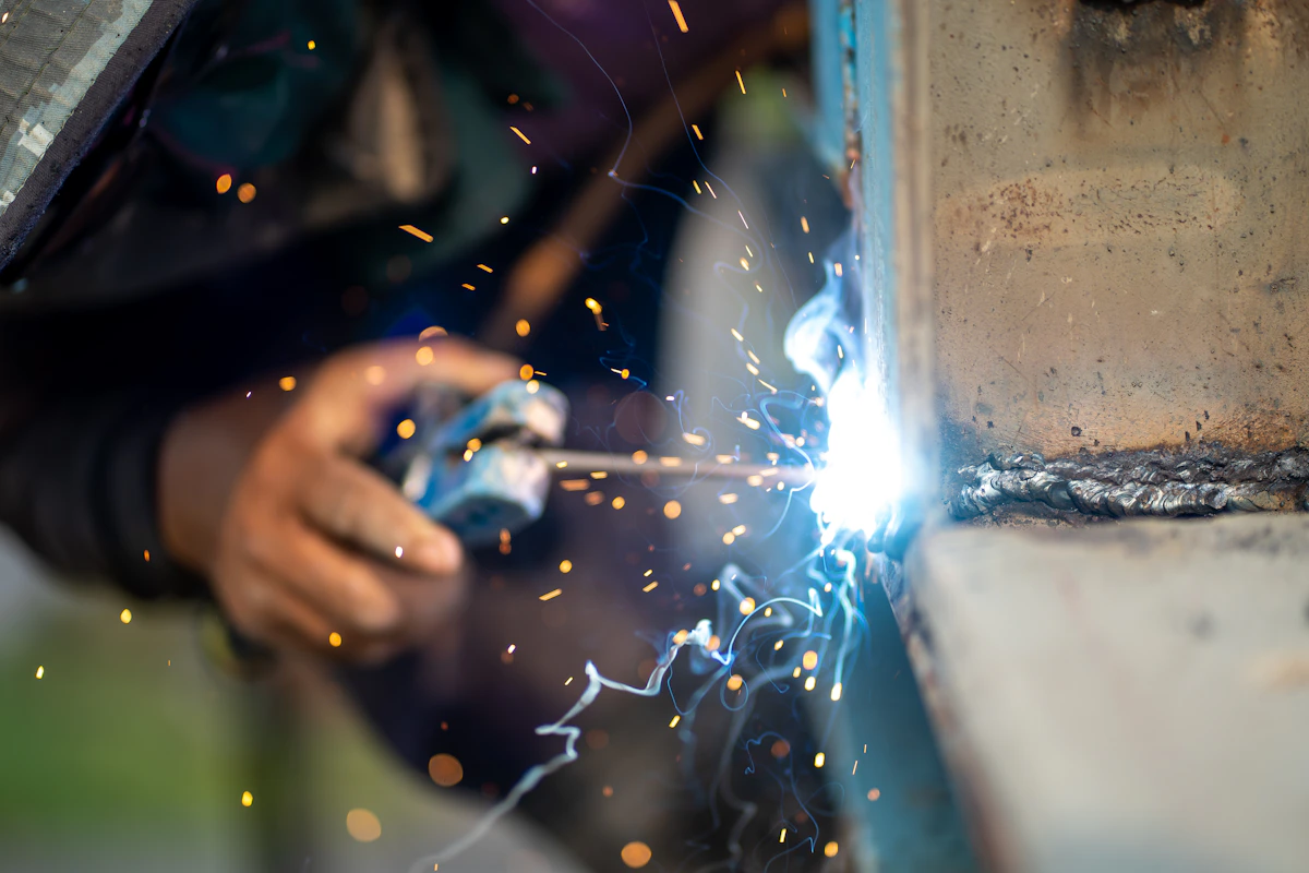 Welder working on metal in a workshop