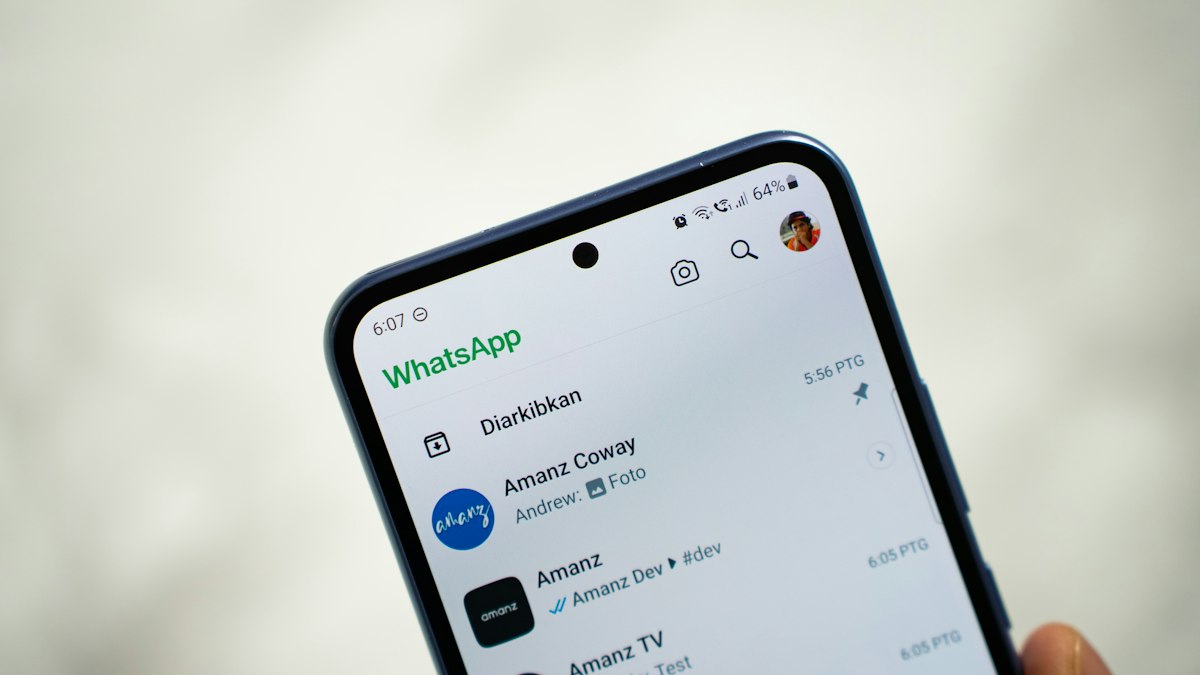 Persona sosteniendo un smartphone para leer un mensaje de WhatsApp