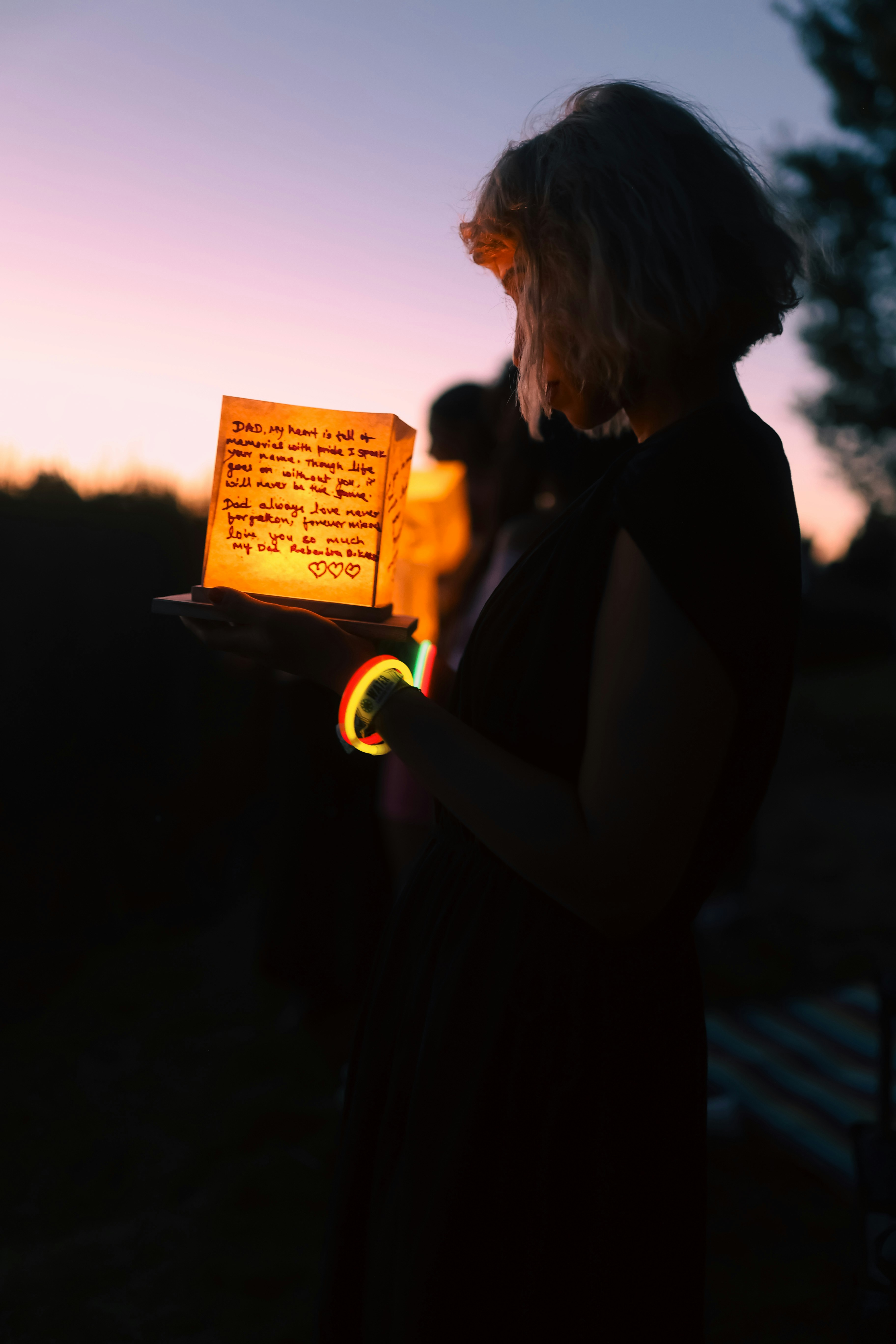 A woman holding a lit up book in her hands