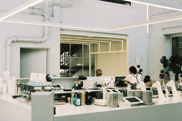 A group of people standing around a kitchen