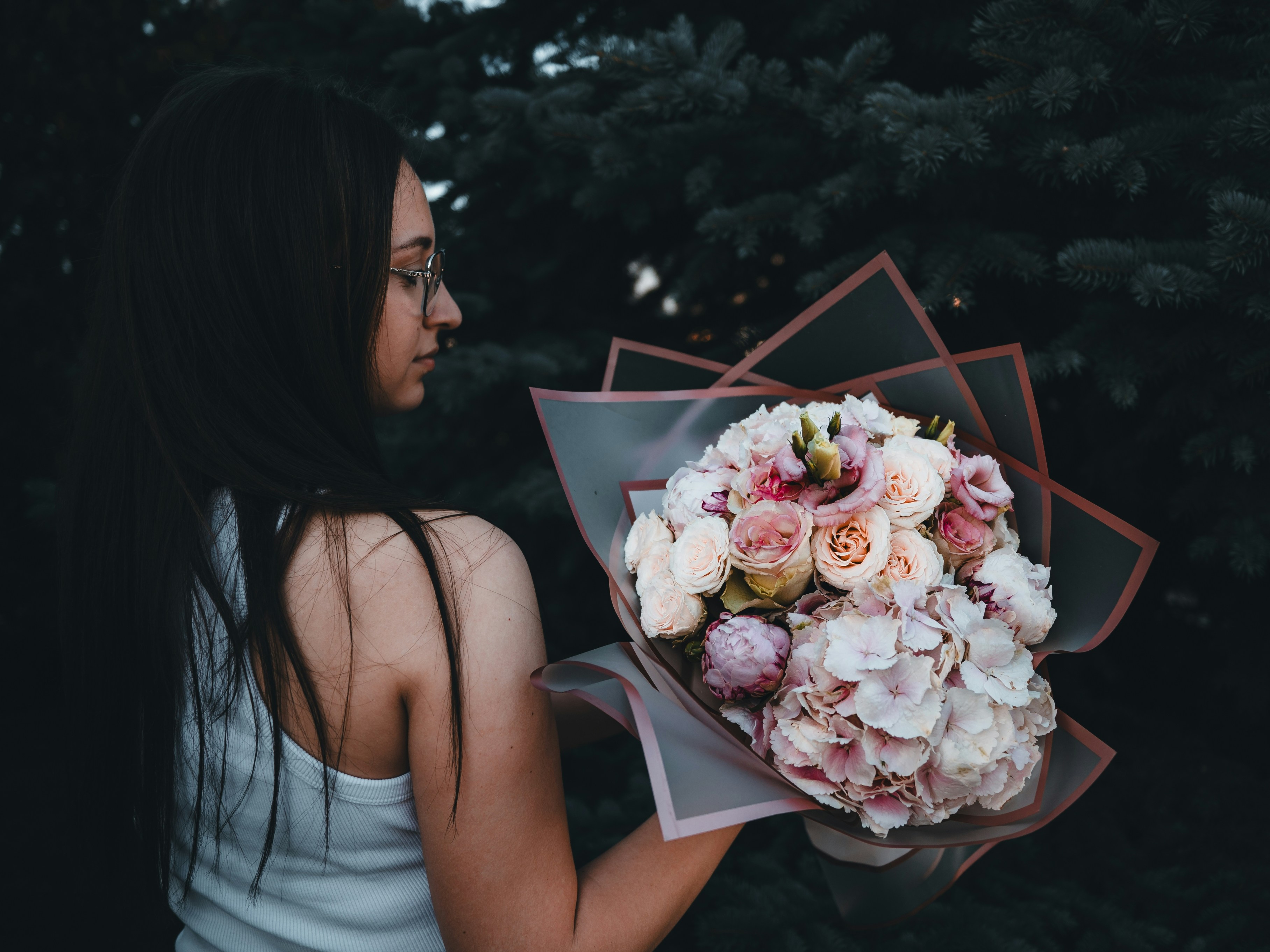 A woman holding a bouquet of flowers in her hand