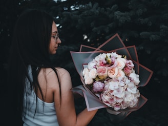 A woman holding a bouquet of flowers in her hand
