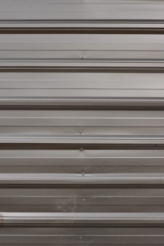 A close up of a metal door with a red handle