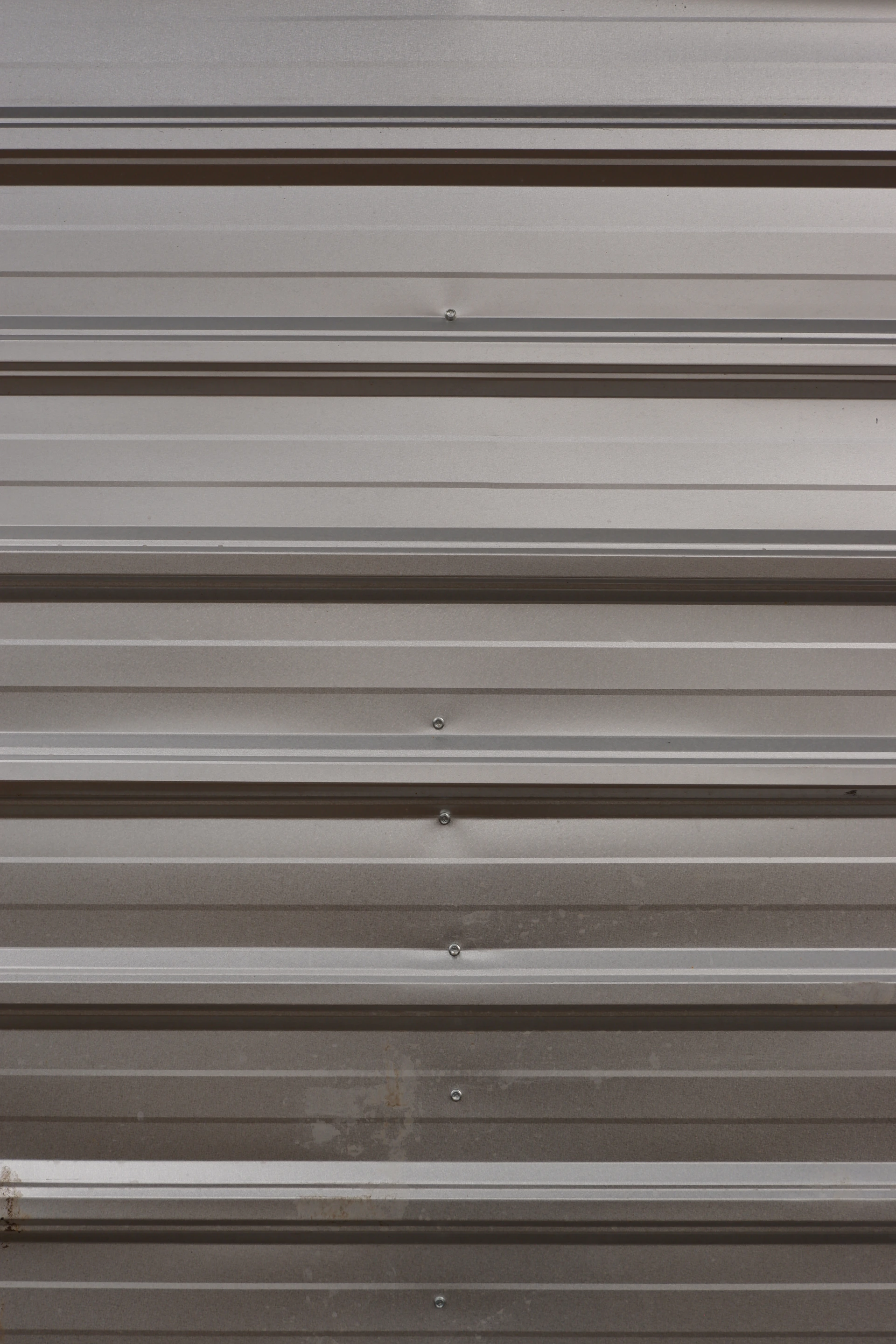 A close up of a metal door with a red handle