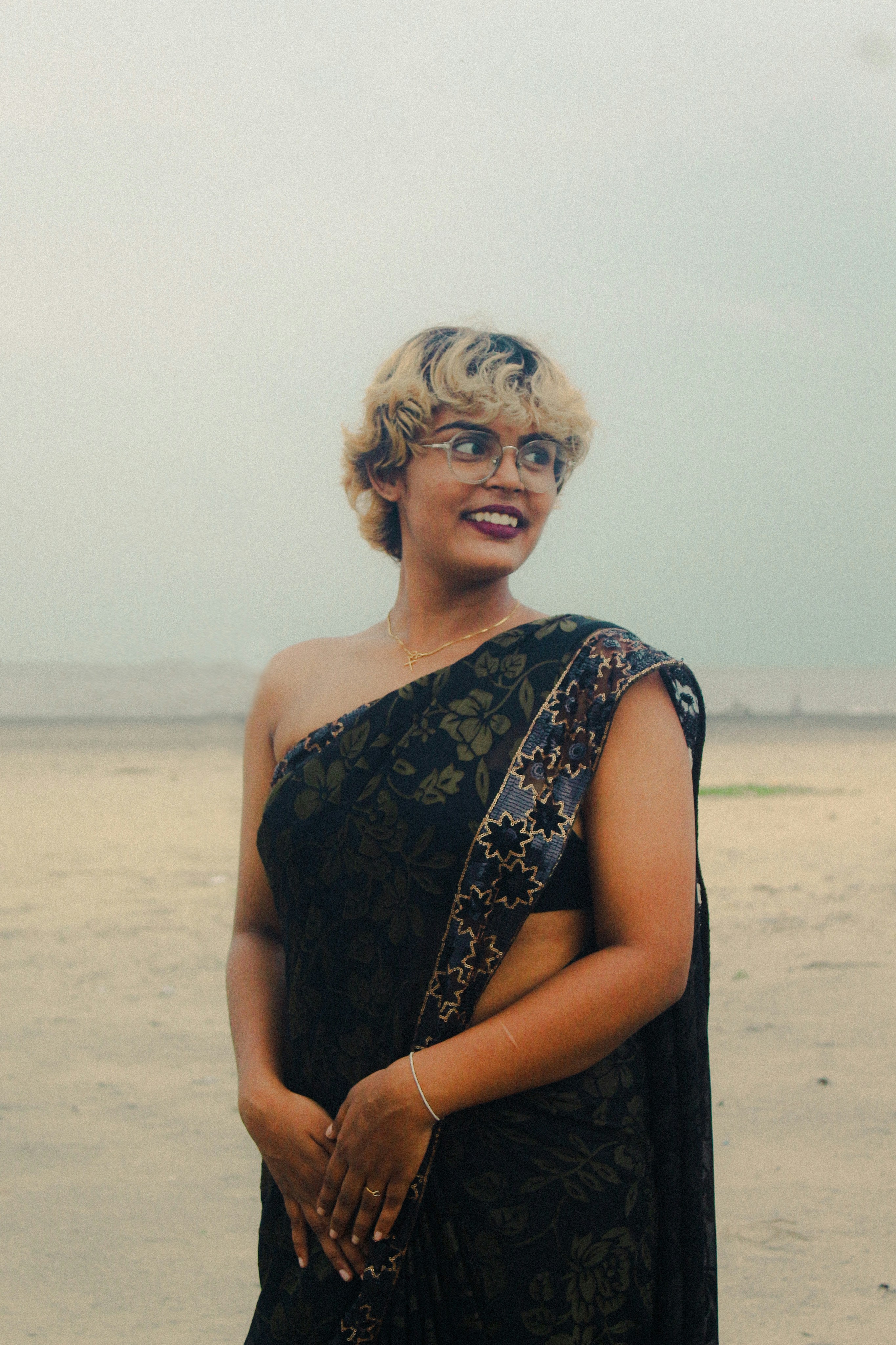 A woman in a black dress standing on a beach photo – Free Grey Image on ...