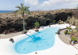 An aerial view of a resort pool with a view of the ocean