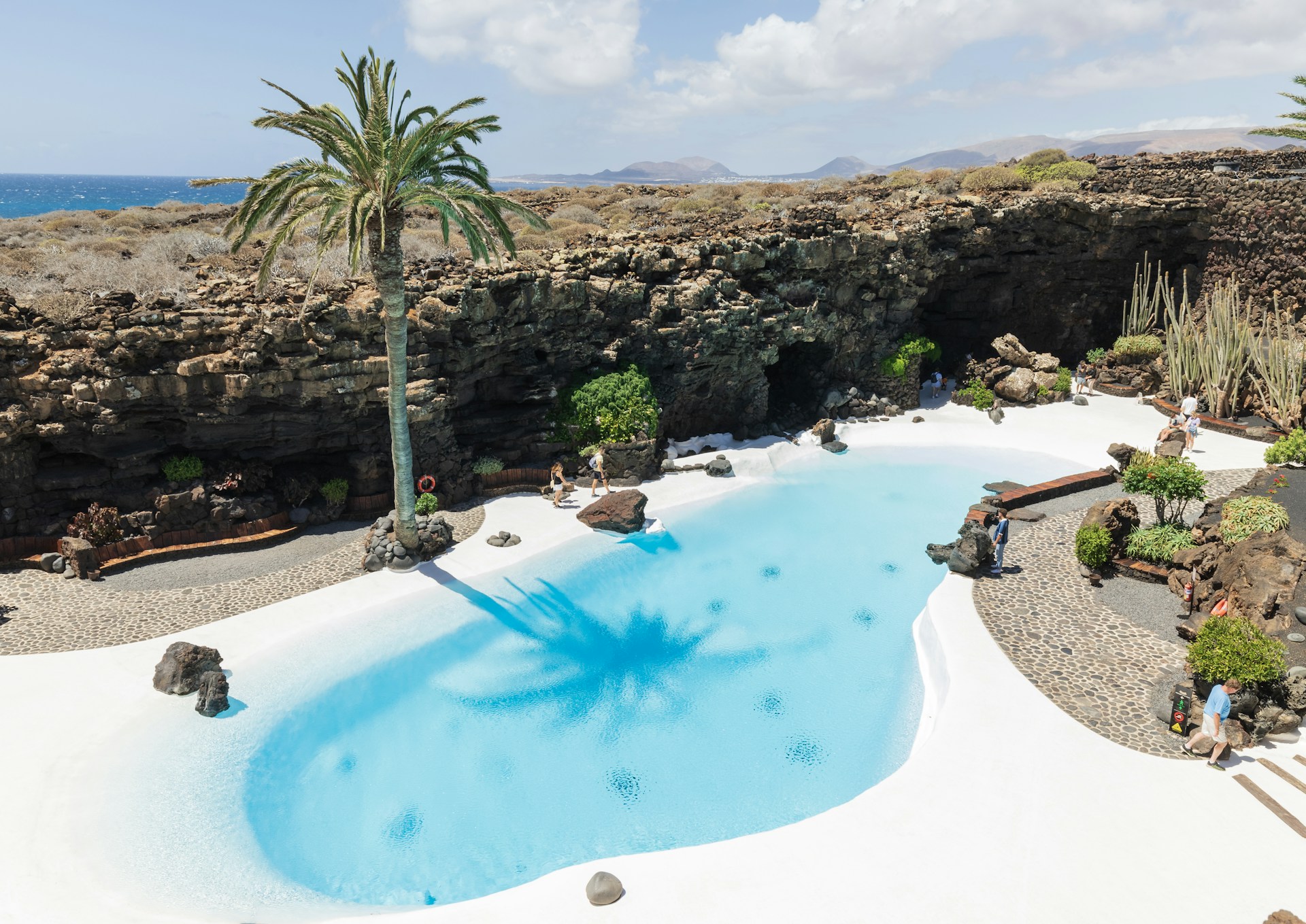 An aerial view of a resort pool with a view of the ocean