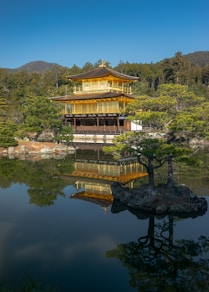 A building sitting on top of a lake next to a forest