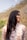A woman with long hair standing in front of a mountain