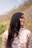 A woman with long hair standing in front of a mountain