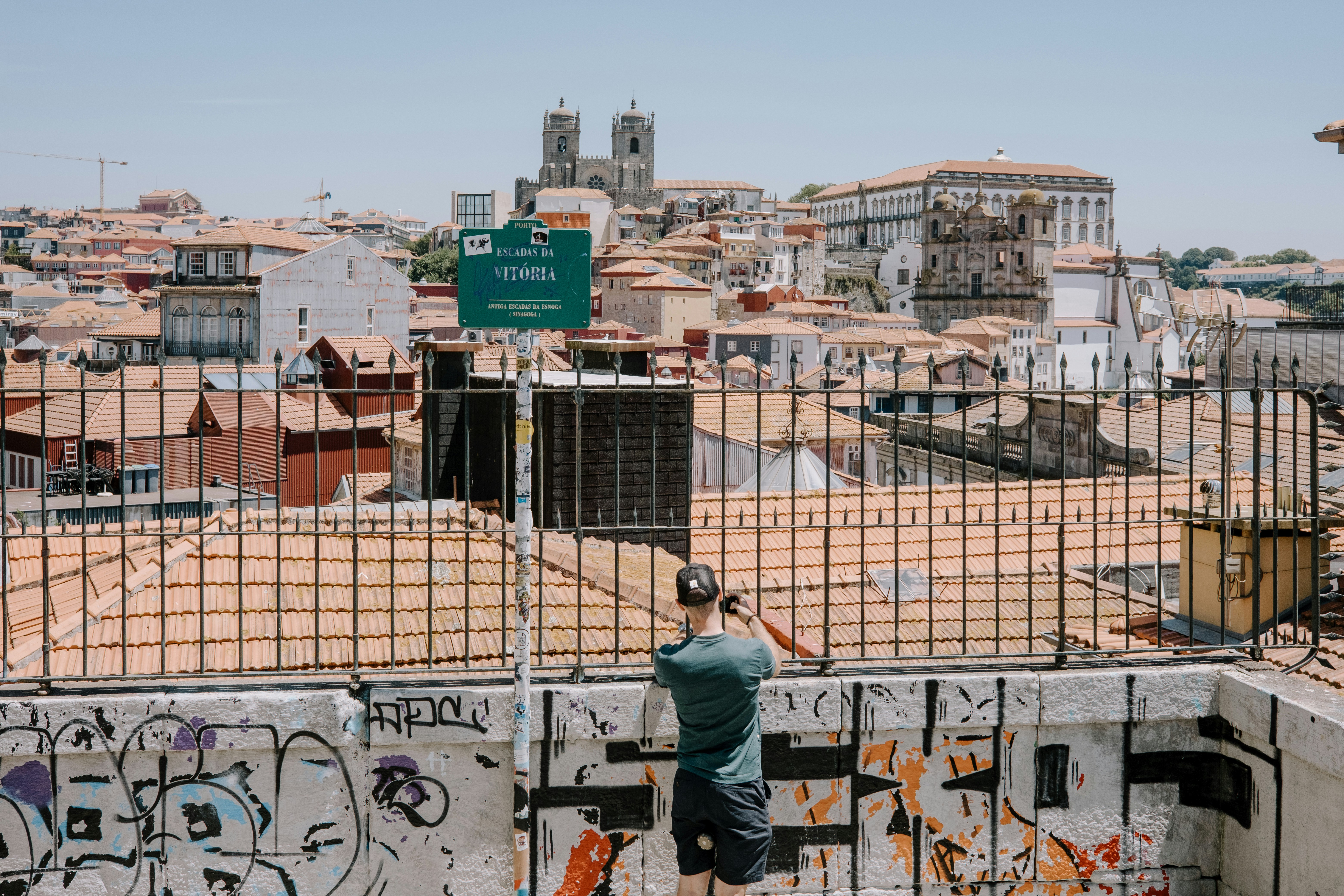 A man standing on top of a metal fence
