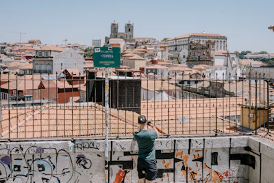 A man standing on top of a metal fence