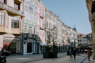 A group of people walking down a street next to tall buildings