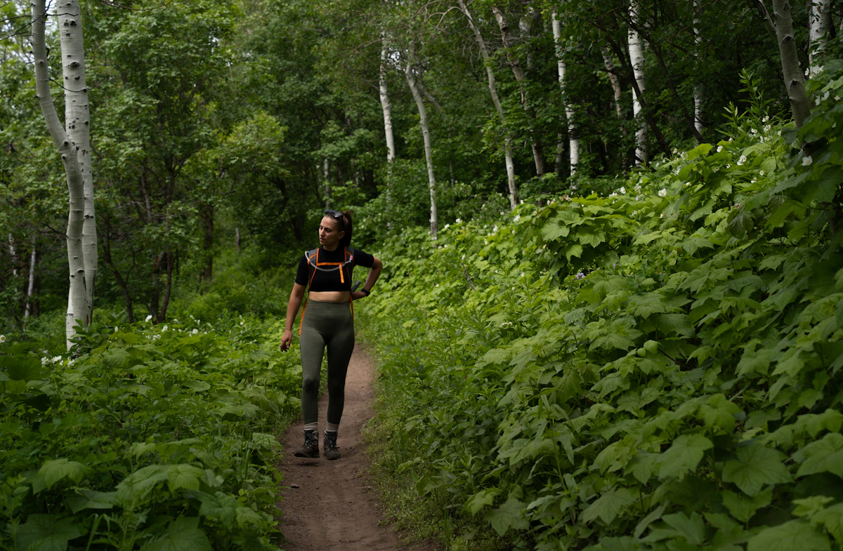 Person geht auf einem grünen Waldweg als Symbol für eine ruhige Bewegungspause