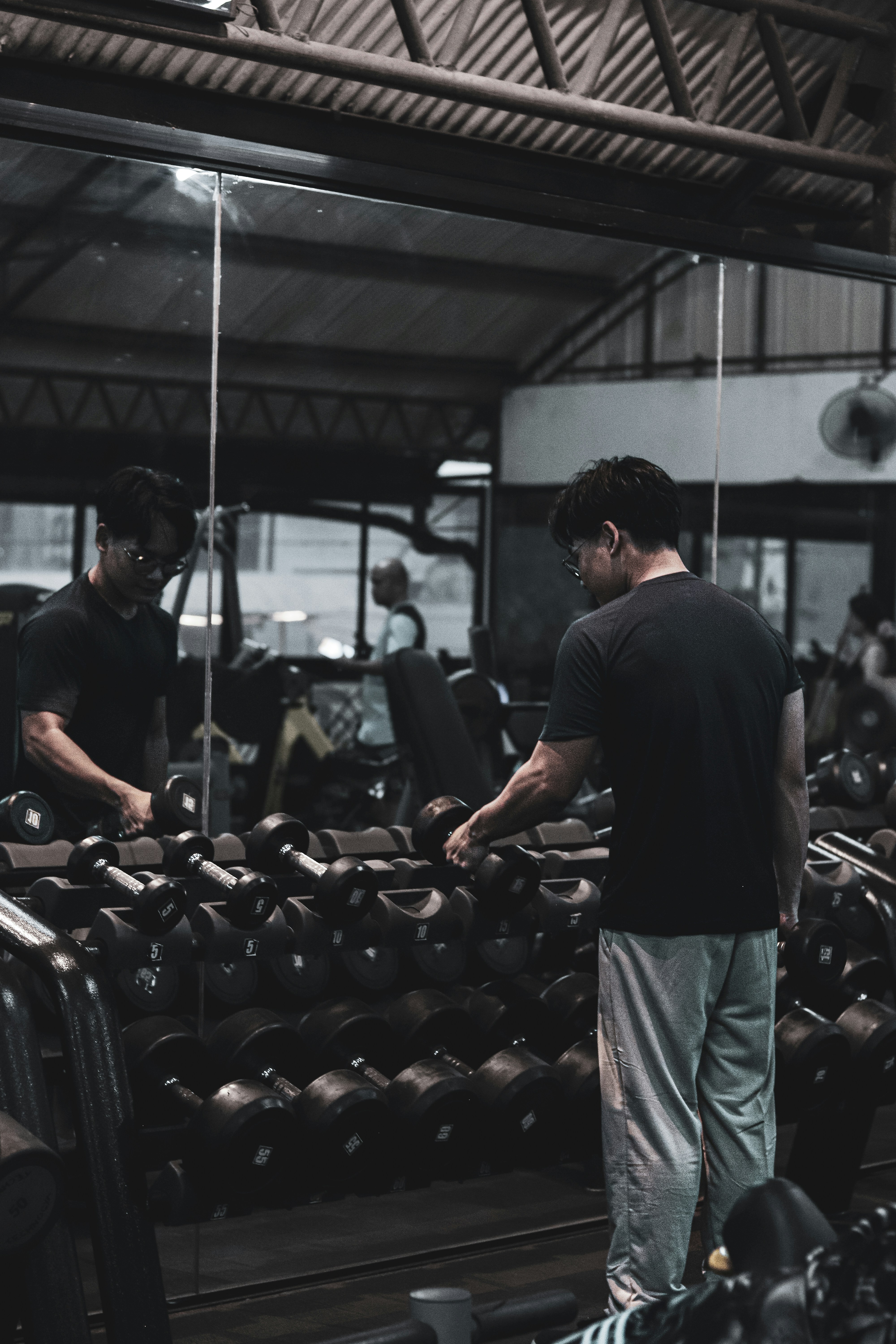 A man standing in front of a mirror in a gym