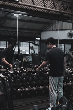 A man standing in front of a mirror in a gym