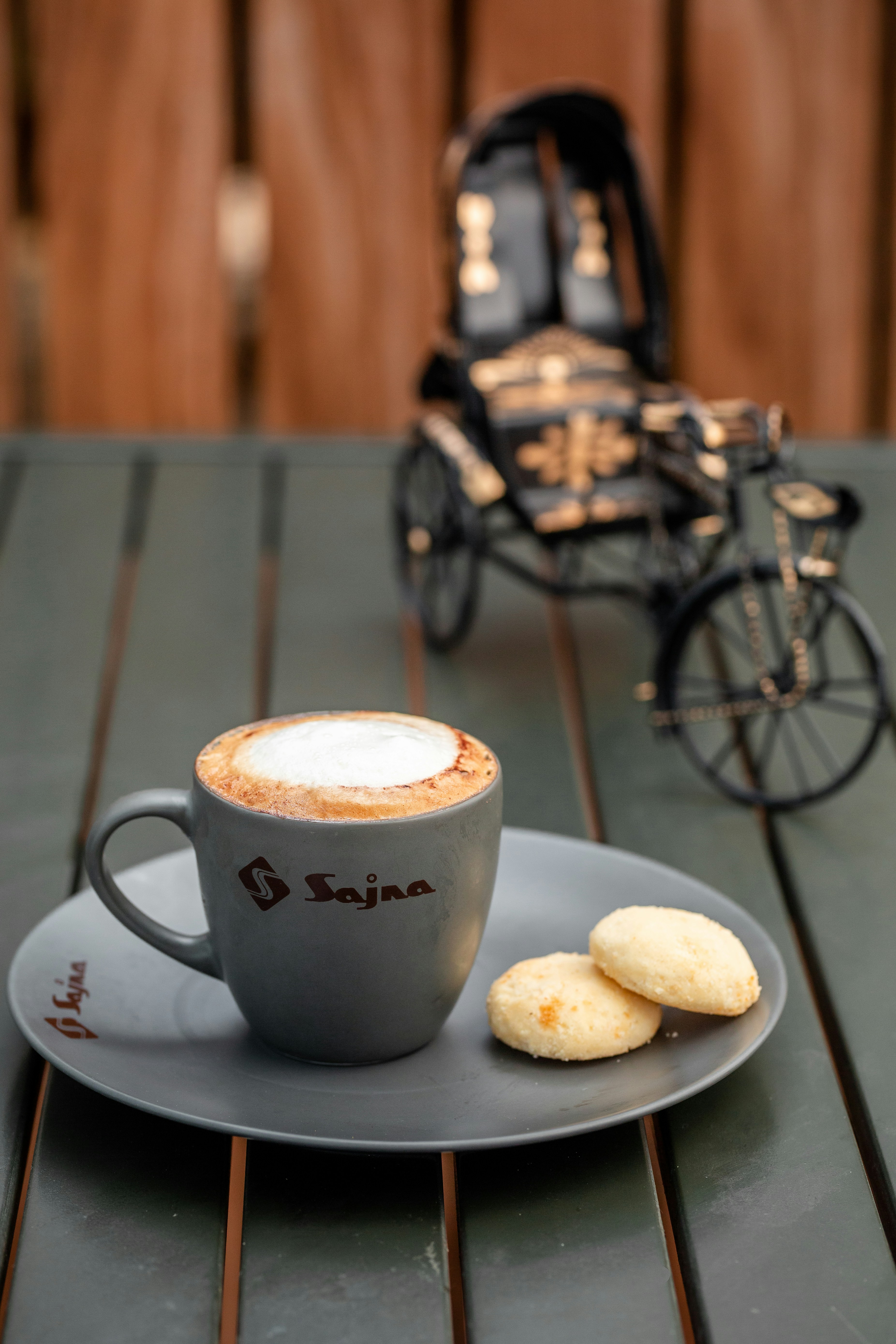 A cup of cappuccino and some cookies on a table