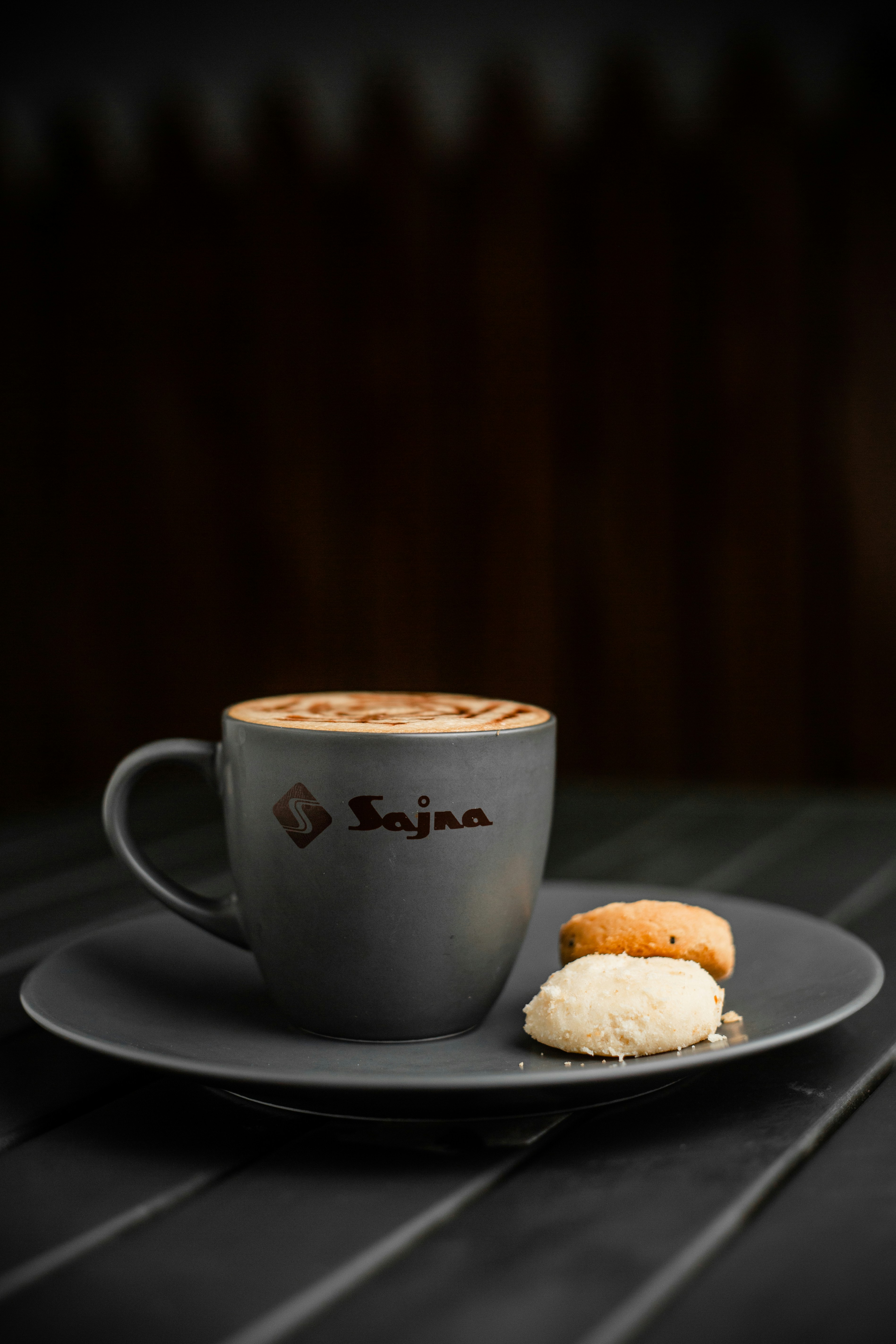 A cup of coffee and a biscuit on a plate